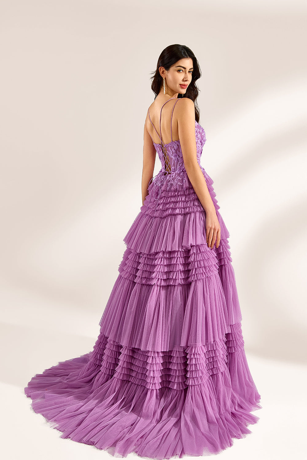 A woman stands against a light background, wearing a lavender tulle gown. It has thin straps, a deep V - neckline, and intricate floral lace embroidery on the bodice. The multi - layered, ruffled tulle skirt with a train creates a romantic and voluminous look, perfect for formal events like weddings or proms, exuding elegance and charm.
2