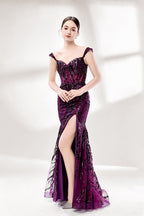 Set against a light background, a woman wears a purple tulle gown embellished with sequin embroidery. It has thin straps, a sweetheart neckline, a sheer bodice patterned with florals, and a mermaid skirt with a high side slit. Silver heels complete the look, with the sparkling sequins and refined silhouette ideal for proms or formal dinners.4