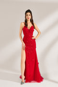 The model has her long hair tied up in a neat style and wears elegant earrings. The dress is a striking red color. It features spaghetti straps, a deep V-neck, and is adorned with delicate floral patterns. There's a high side slit that adds a touch of allure, and the tulle skirt flows gracefully. It's perfect for formal occasions like galas or weddings.1