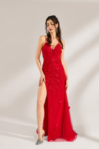 The model has her long hair tied up in a neat style and wears elegant earrings. The dress is a striking red color. It features spaghetti straps, a deep V-neck, and is adorned with delicate floral patterns. There's a high side slit that adds a touch of allure, and the tulle skirt flows gracefully. It's perfect for formal occasions like galas or weddings.3