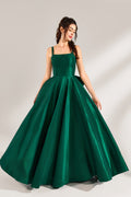 A woman stands against a light background, wearing a dark - green satin gown. It features square neckline, wide straps, and a bow at the waist. The voluminous skirt and elegant silhouette exude sophistication, perfect for formal events like galas or weddings, radiating timeless charm.1