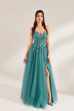 In front of a light - colored background, a woman is dressed in a teal tulle strapless gown. It has a sweetheart neckline, with the bodice adorned with delicate lace embroidery, and a high side slit. The voluminous tulle skirt, which has a slight shimmer, gives an elegant and romantic appearance, ideal for formal events such as proms or weddings.1