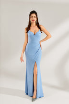 A woman stands against a light background, wearing a light - blue shimmering gown. It features thin straps, a deep V - neckline, a draped bodice, and a high side slit. The elegant design creates a glamorous look, perfect for formal events like galas or red - carpet occasions.
1
