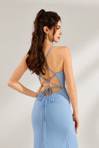 A woman stands against a light background, wearing a light - blue shimmering gown. It features thin straps, a deep V - neckline, a draped bodice, and a high side slit. The elegant design creates a glamorous look, perfect for formal events like galas or red - carpet occasions.6