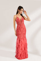 A woman stands against a light background, wearing a coral - pink tulle and lace mermaid gown. It features thin straps, a deep V - neckline with lace - up details, and intricate floral embroidery. The layered, ruffled tulle skirt creates a romantic and glamorous look, perfect for formal events like proms or weddings.3