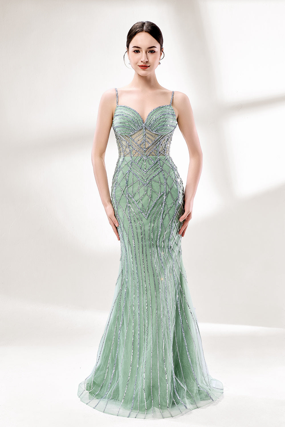 A mannequin presents a pink tulle gown with silver sequin embroidery against a light backdrop. It boasts thin straps, a sheer bodice with geometric patterns, and a mermaid - style skirt. The shimmering sequins and intricate design make it a standout choice for proms or formal events.1