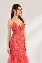 A woman stands against a light background, wearing a coral - pink tulle and lace mermaid gown. It features thin straps, a deep V - neckline with lace - up details, and intricate floral embroidery. The layered, ruffled tulle skirt creates a romantic and glamorous look, perfect for formal events like proms or weddings.5