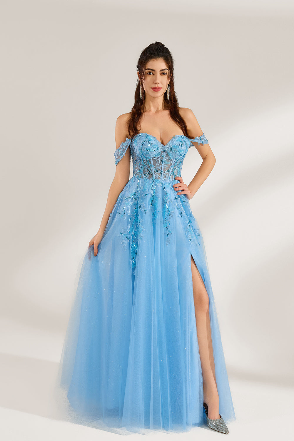 Set against a light backdrop, a woman is clad in a light - blue tulle off - shoulder gown. It boasts a sweetheart neckline, with the bodice embellished by intricate lace embroidery and sequins, and a high side slit. The voluminous tulle skirt, shimmering subtly, lends an elegant and romantic touch, ideal for formal events such as proms or weddings.1
