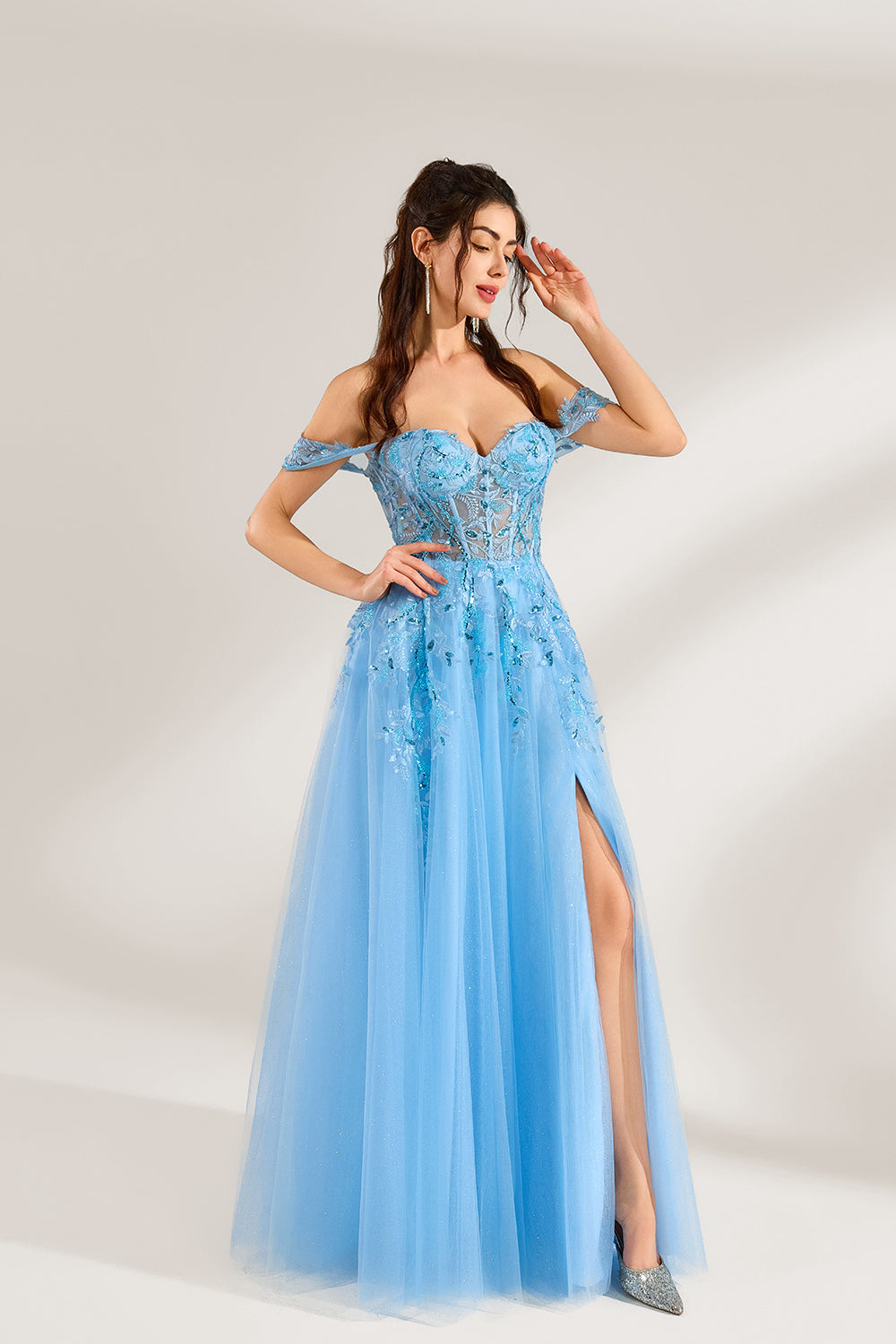 Set against a light backdrop, a woman is clad in a light - blue tulle off - shoulder gown. It boasts a sweetheart neckline, with the bodice embellished by intricate lace embroidery and sequins, and a high side slit. The voluminous tulle skirt, shimmering subtly, lends an elegant and romantic touch, ideal for formal events such as proms or weddings.3