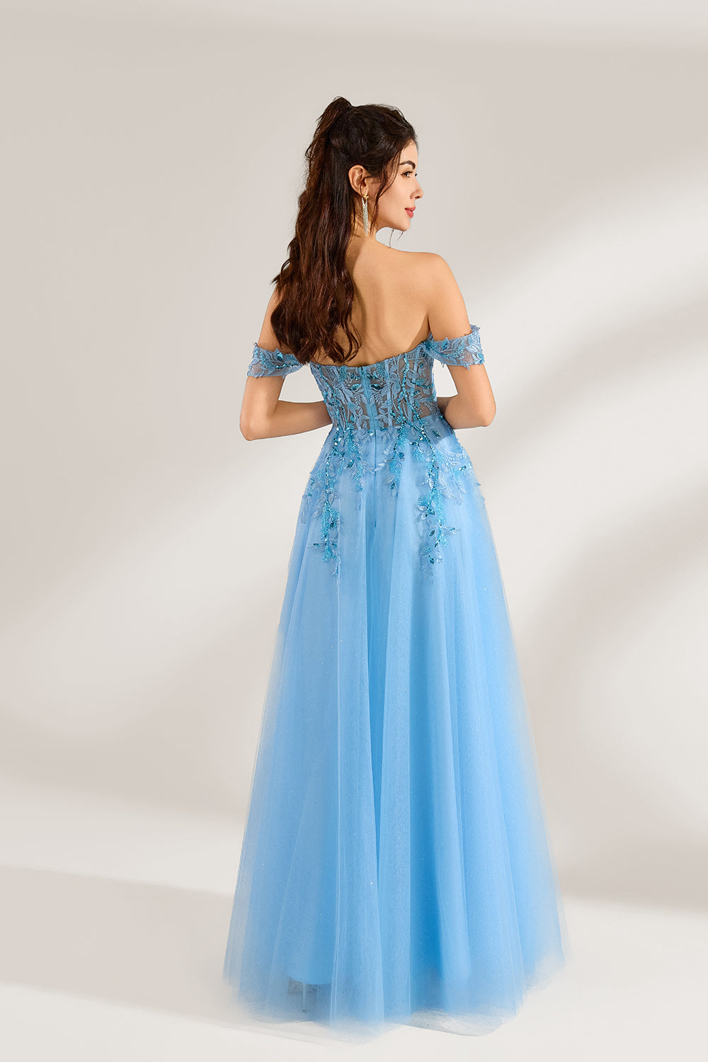 Set against a light backdrop, a woman is clad in a light - blue tulle off - shoulder gown. It boasts a sweetheart neckline, with the bodice embellished by intricate lace embroidery and sequins, and a high side slit. The voluminous tulle skirt, shimmering subtly, lends an elegant and romantic touch, ideal for formal events such as proms or weddings.2