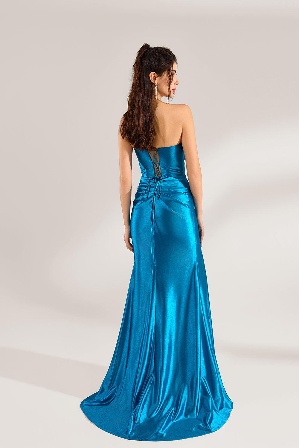 A woman stands against a light background, wearing a turquoise satin strapless gown. It features a draped bodice, a high side slit, and a figure - hugging silhouette. The elegant design creates a glamorous look, perfect for formal events like galas or red - carpet occasions.
2