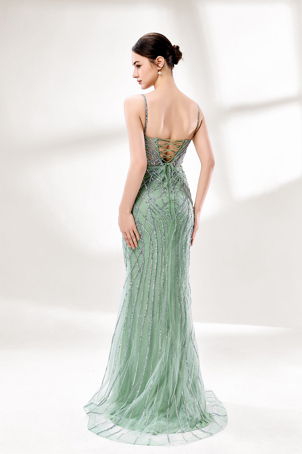 A mannequin presents a pink tulle gown with silver sequin embroidery against a light backdrop. It boasts thin straps, a sheer bodice with geometric patterns, and a mermaid - style skirt. The shimmering sequins and intricate design make it a standout choice for proms or formal events.2