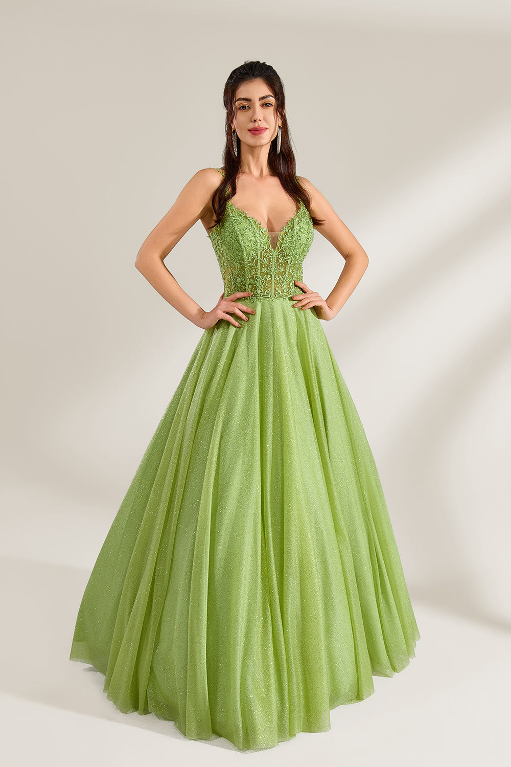 A woman stands against a light background, wearing a lime - green tulle gown. It features thin straps, a deep V - neckline, and intricate lace embroidery on the bodice. The voluminous tulle skirt creates a romantic and elegant look, perfect for formal events like proms or weddings.3