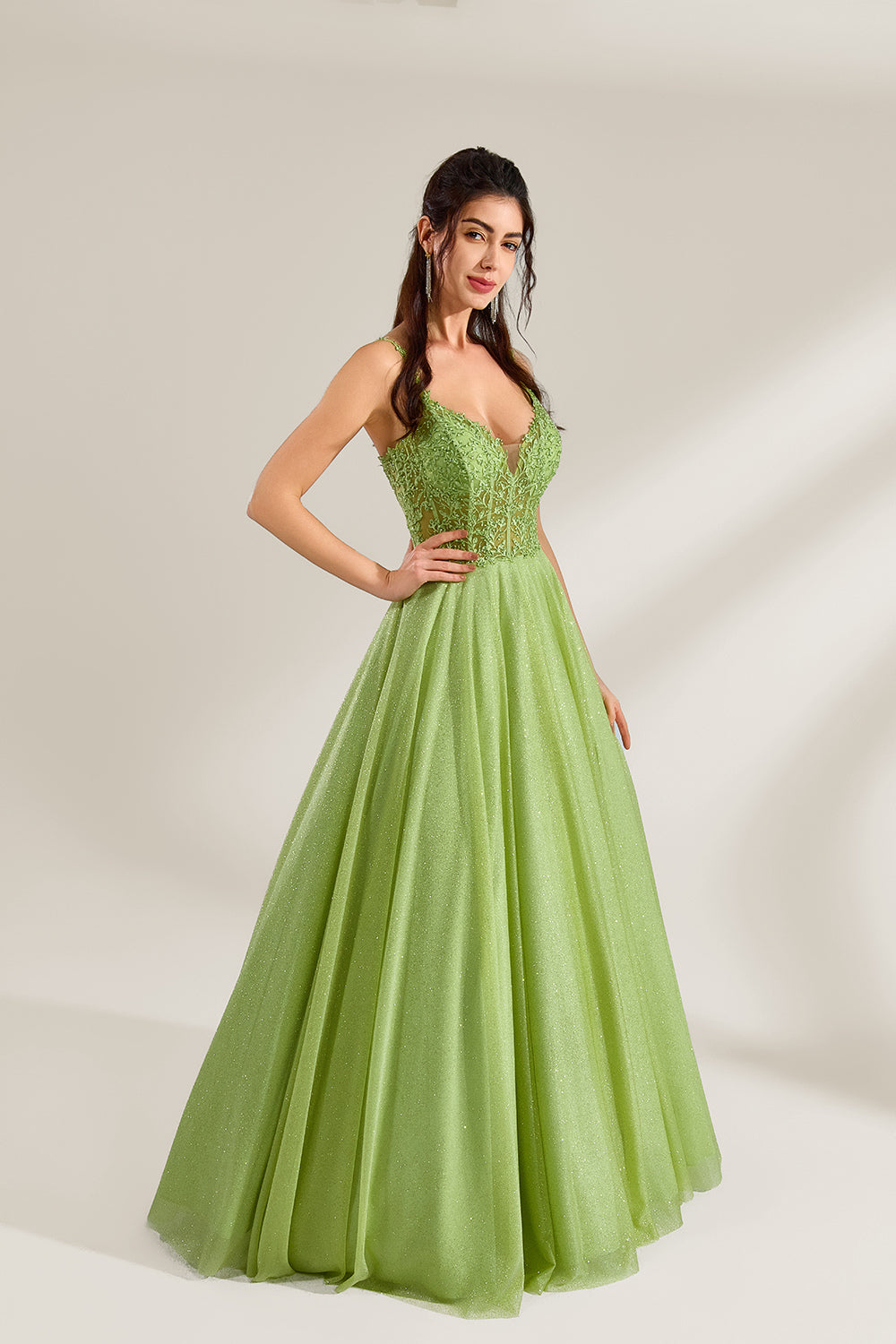 A woman stands against a light background, wearing a lime - green tulle gown. It features thin straps, a deep V - neckline, and intricate lace embroidery on the bodice. The voluminous tulle skirt creates a romantic and elegant look, perfect for formal events like proms or weddings.4