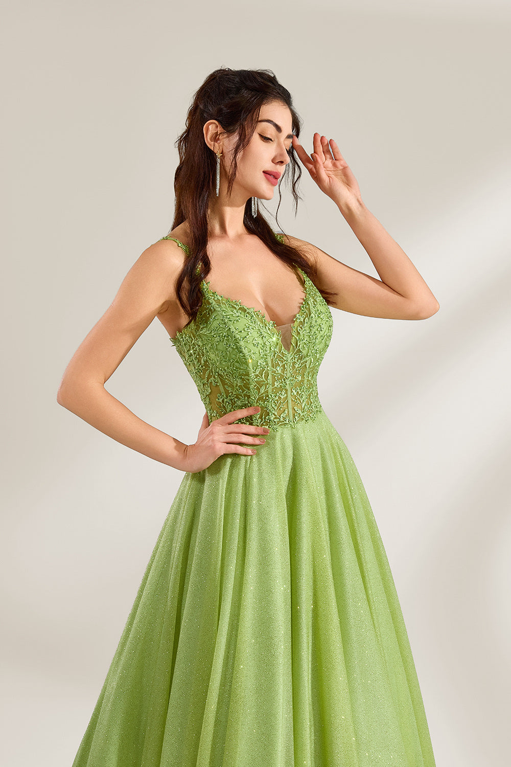 A woman stands against a light background, wearing a lime - green tulle gown. It features thin straps, a deep V - neckline, and intricate lace embroidery on the bodice. The voluminous tulle skirt creates a romantic and elegant look, perfect for formal events like proms or weddings.5