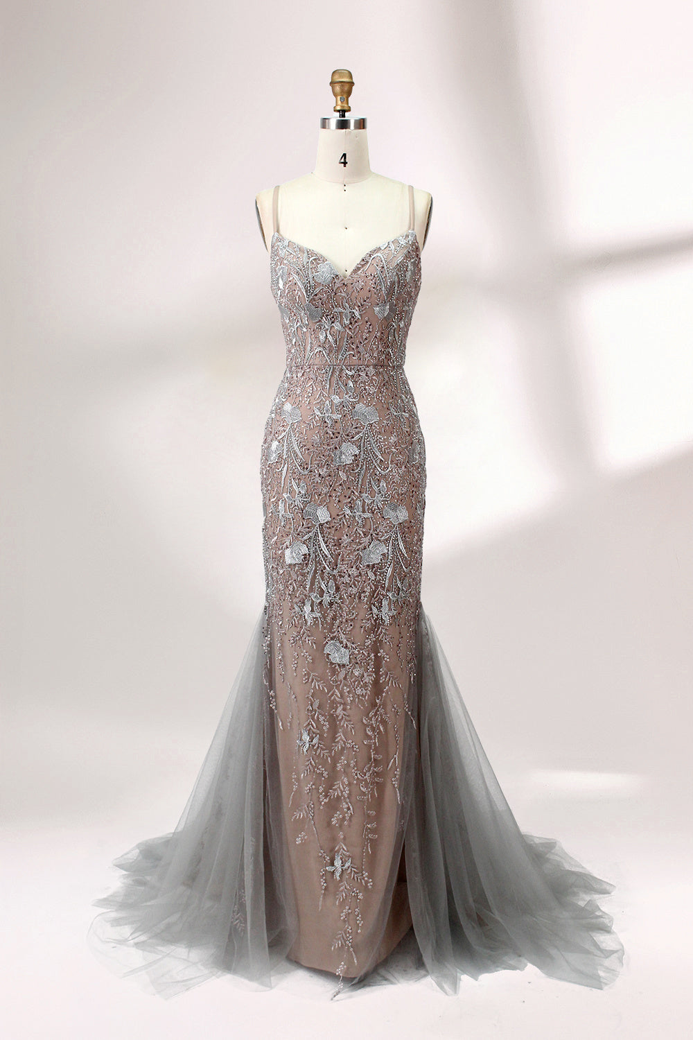 Showcased on a mannequin is a taupe - toned mermaid - cut gown. It has thin straps, a sweetheart neckline, and is embellished with delicate silver floral embroidery all over, plus a flowing tulle skirt. The refined design gives off a glamorous aura, ideal for formal events such as proms or weddings.1