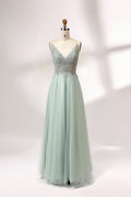A mannequin showcases a light - green tulle gown with a lace - embroidered, sheer bodice. It has thin straps, a deep V - neckline, and a voluminous skirt. The delicate lace and flowing tulle create a romantic look, perfect for formal events like weddings or proms, exuding elegance.1
