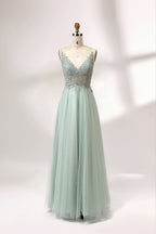 A mannequin showcases a light - green tulle gown with a lace - embroidered, sheer bodice. It has thin straps, a deep V - neckline, and a voluminous skirt. The delicate lace and flowing tulle create a romantic look, perfect for formal events like weddings or proms, exuding elegance.1
