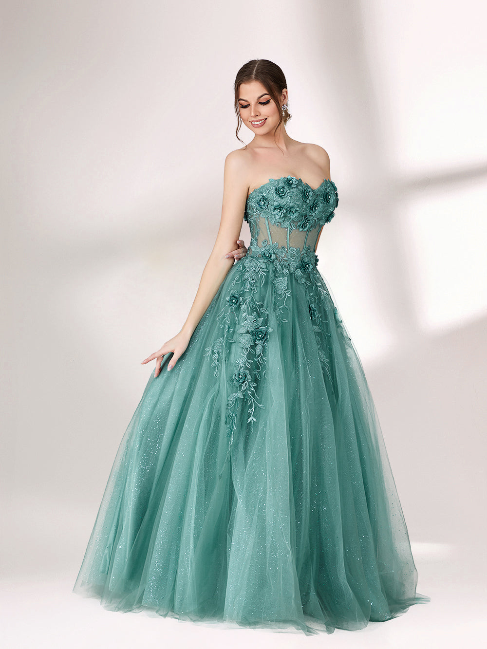 Bathed in soft light, a woman radiates grace in a mint - green evening gown. With floral details, sheer waist, and tulle skirt, it crafts a romantic and elegant look for formal events.1