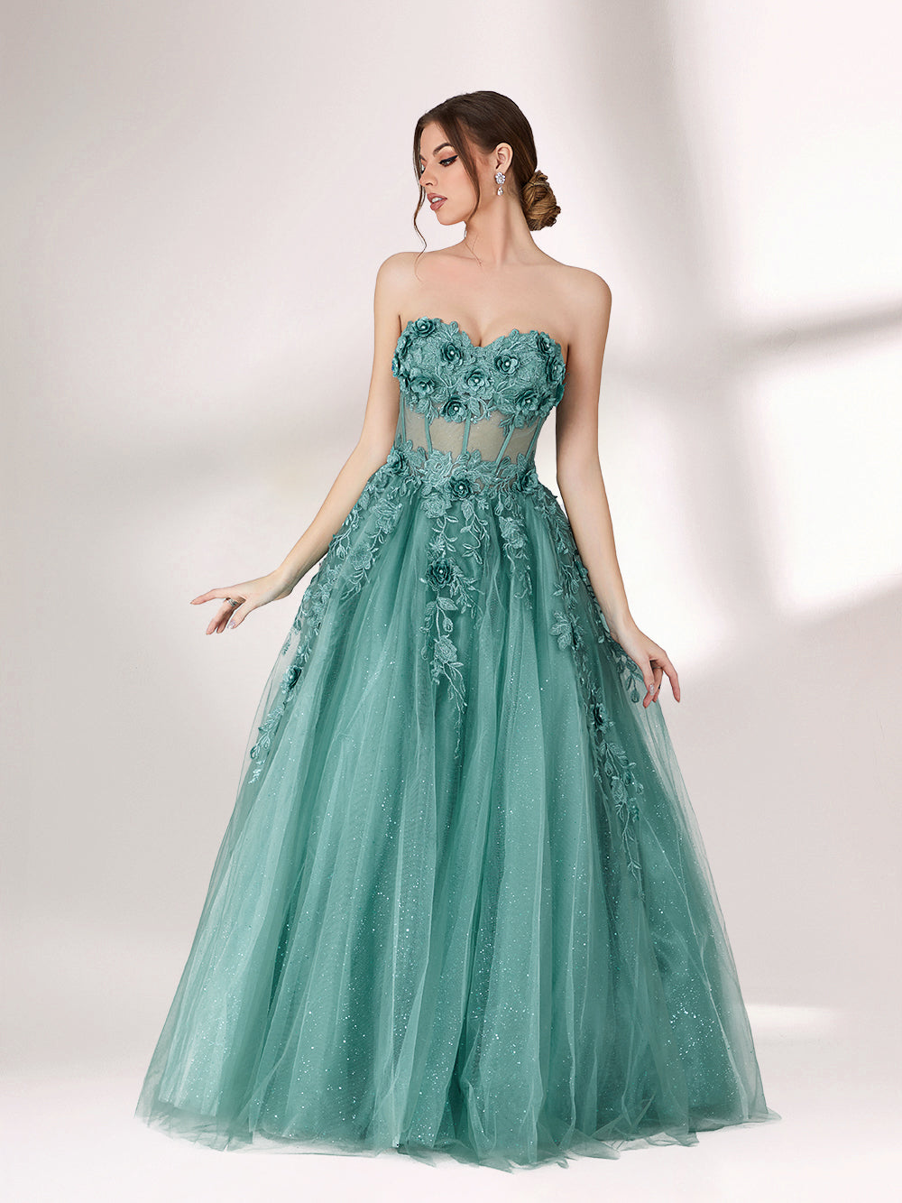 Bathed in soft light, a woman radiates grace in a mint - green evening gown. With floral details, sheer waist, and tulle skirt, it crafts a romantic and elegant look for formal events.5