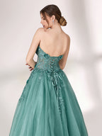 Bathed in soft light, a woman radiates grace in a mint - green evening gown. With floral details, sheer waist, and tulle skirt, it crafts a romantic and elegant look for formal events.4