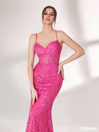 A woman stands against a light background, wearing a bright pink mermaid - style evening gown. It features thin spaghetti straps, a sweetheart neckline, and is covered in shimmering sequins with a sheer, embellished bodice detail. The elegant and glamorous design is perfect for formal events.6