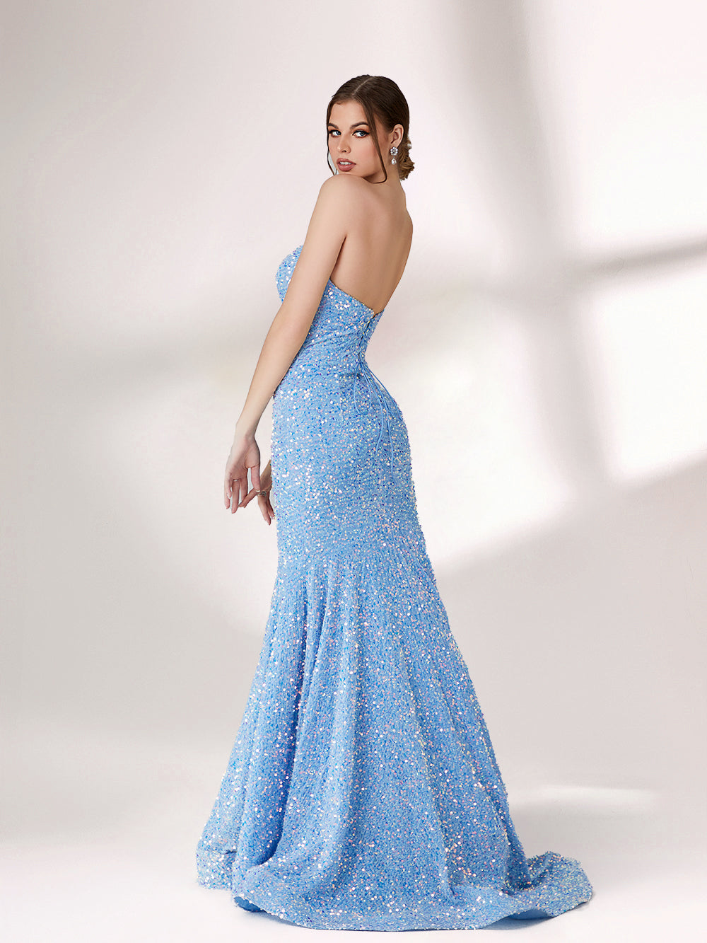 A woman stands against a light - colored backdrop, donning a stunning light blue mermaid - style evening gown. The strapless design features a sweetheart neckline, perfectly highlighting her shoulders and collarbone. The entire gown is intricately adorned with shimmering sequins, creating a dazzling effect that catches the light with every movement. This glamorous and elegant piece is an ideal choice for formal galas and upscale evening affairs.3
