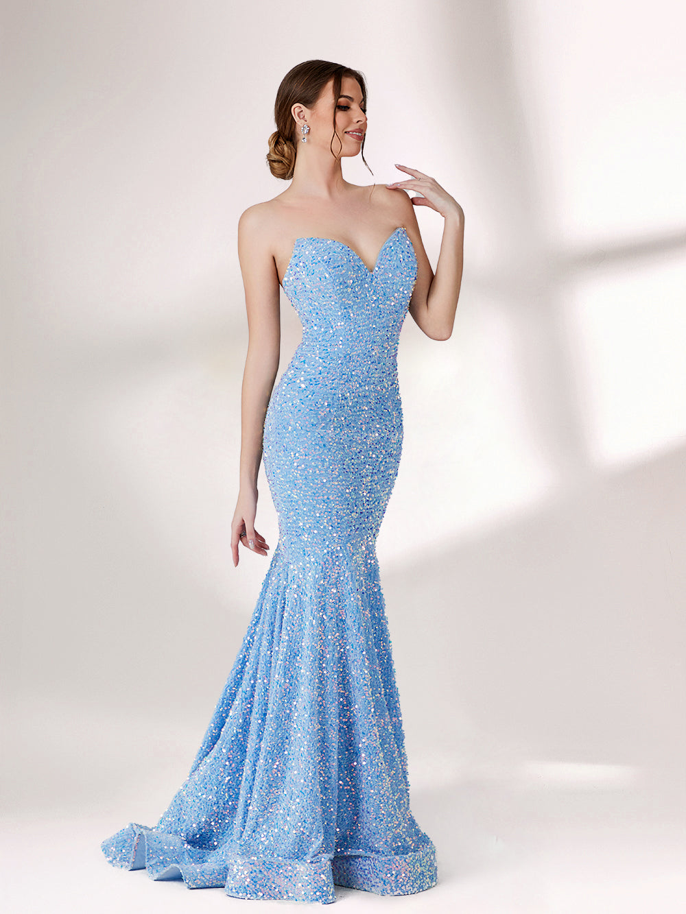 A woman stands against a light - colored backdrop, donning a stunning light blue mermaid - style evening gown. The strapless design features a sweetheart neckline, perfectly highlighting her shoulders and collarbone. The entire gown is intricately adorned with shimmering sequins, creating a dazzling effect that catches the light with every movement. This glamorous and elegant piece is an ideal choice for formal galas and upscale evening affairs.5