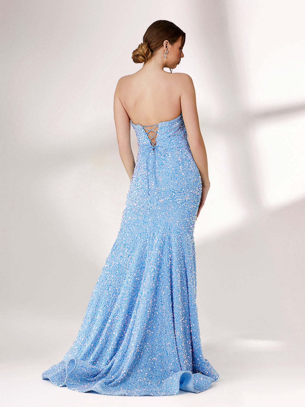 A woman stands against a light - colored backdrop, donning a stunning light blue mermaid - style evening gown. The strapless design features a sweetheart neckline, perfectly highlighting her shoulders and collarbone. The entire gown is intricately adorned with shimmering sequins, creating a dazzling effect that catches the light with every movement. This glamorous and elegant piece is an ideal choice for formal galas and upscale evening affairs.2