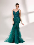 In soft lighting, a woman shines in a dark green evening gown. With sequin details, a mermaid silhouette, and tulle skirt, it creates a glamorous and elegant look for formal events.3