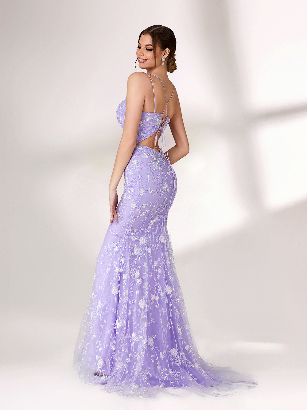 A woman stands against a light background, wearing a lavender mermaid - style evening gown. It has thin spaghetti straps, a sweetheart neckline, and is adorned with delicate white floral embroidery and beadwork throughout. The elegant design is perfect for formal events.4