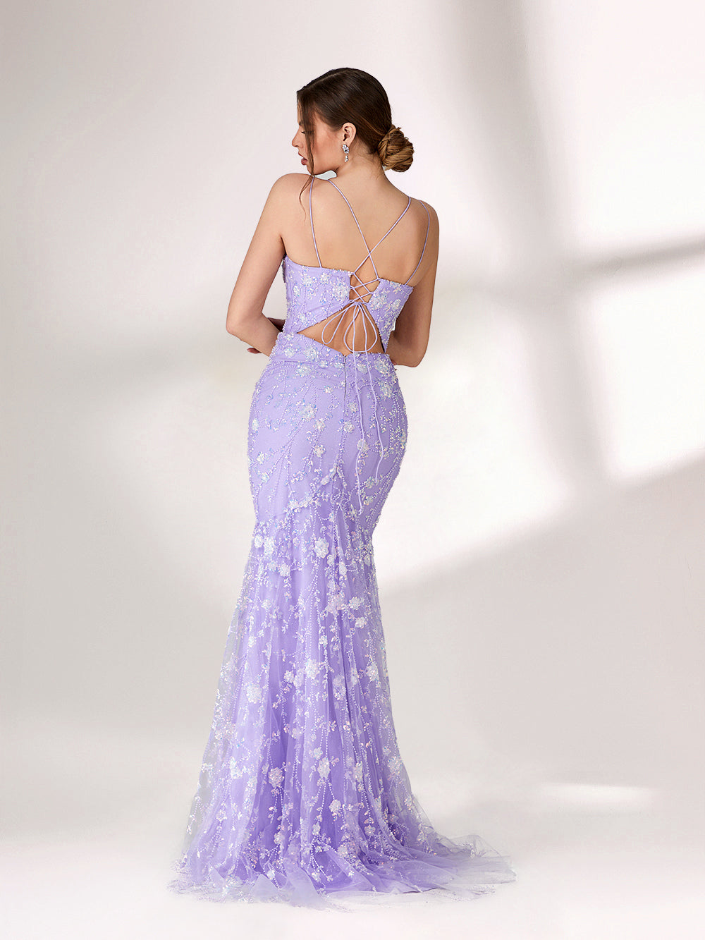 A woman stands against a light background, wearing a lavender mermaid - style evening gown. It has thin spaghetti straps, a sweetheart neckline, and is adorned with delicate white floral embroidery and beadwork throughout. The elegant design is perfect for formal events.2
