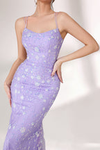 A woman stands against a light background, wearing a lavender mermaid - style evening gown. It has thin spaghetti straps, a sweetheart neckline, and is adorned with delicate white floral embroidery and beadwork throughout. The elegant design is perfect for formal events.7