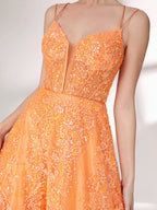 A woman stands against a light background, wearing an orange evening gown. It has thin spaghetti straps, a deep V - neckline, and is adorned with delicate floral - like sequin embroidery all over. The voluminous tulle skirt creates an elegant and glamorous look, perfect for formal events.7