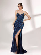 A woman stands against a light background, wearing a navy blue evening gown. It features thin spaghetti straps, a deep V - neckline, and diagonal stripes of shimmering blue embellishments. The dress has a high side slit, creating an elegant and sexy look, perfect for formal events.3