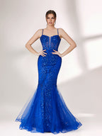 A woman stands against a light background, wearing a bright blue mermaid - style evening gown. It features thin spaghetti straps, a sheer panel at the neckline, and is covered in sparkling sequins. The tulle skirt flares out elegantly, creating a glamorous look perfect for formal events.3