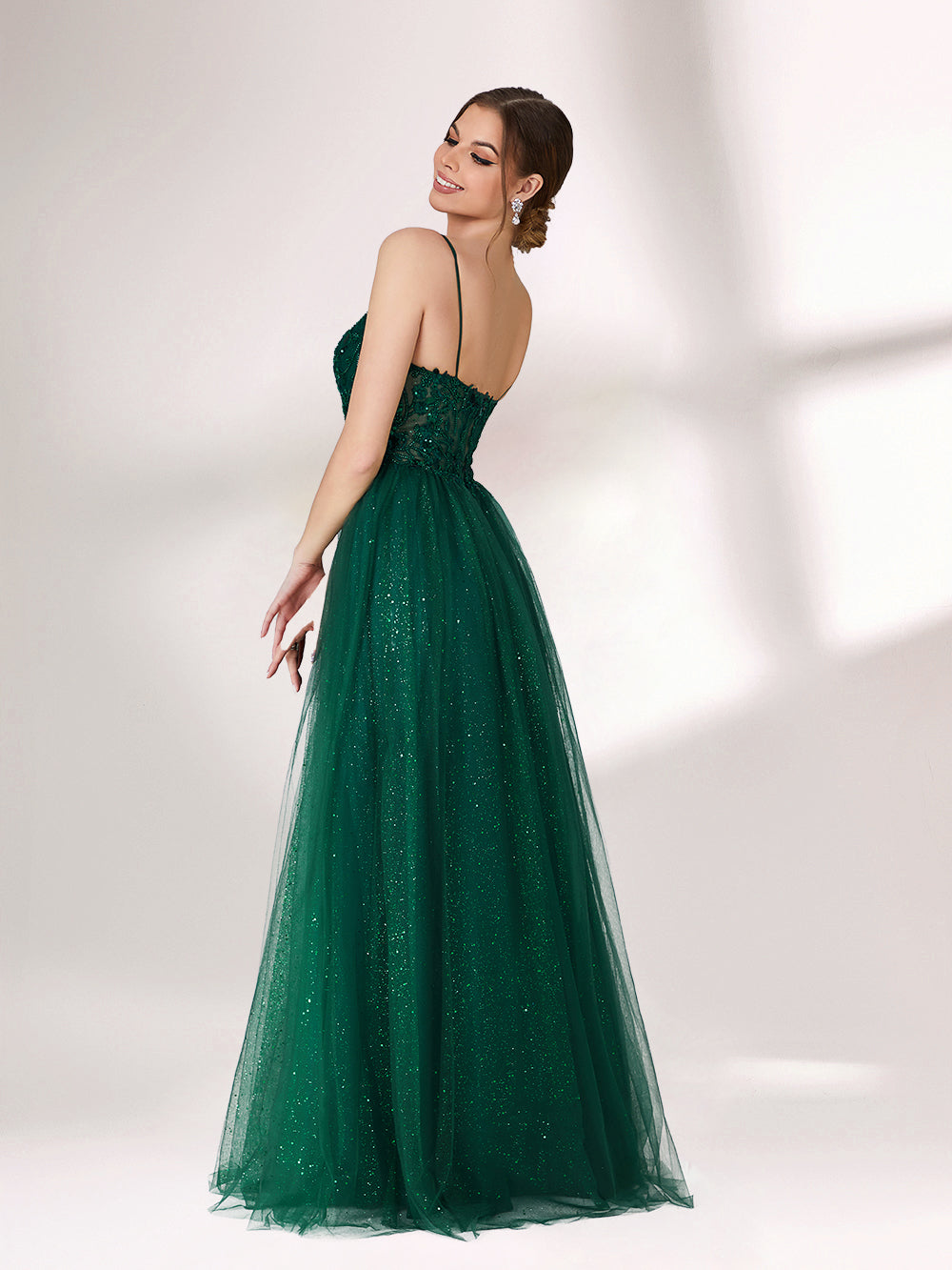 Bathed in soft light, a woman radiates elegance in a dark green evening gown. With sequin - dotted tulle, lace bodice, and spaghetti straps, it crafts a dreamy and refined look for formal events.2