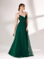 Bathed in soft light, a woman radiates elegance in a dark green evening gown. With sequin - dotted tulle, lace bodice, and spaghetti straps, it crafts a dreamy and refined look for formal events.4