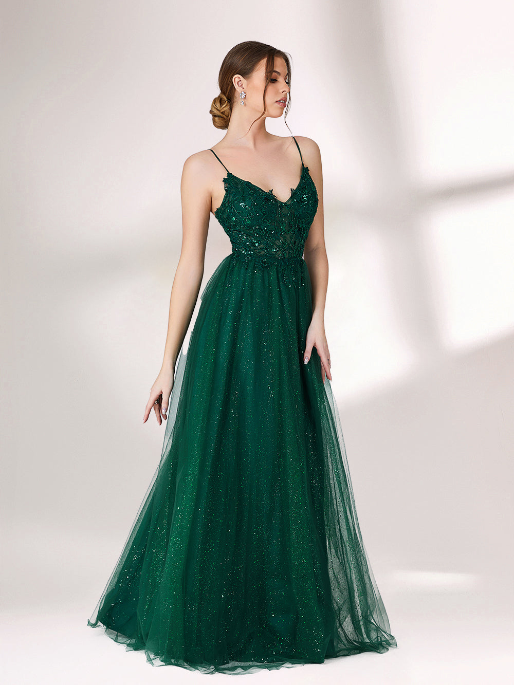 Bathed in soft light, a woman radiates elegance in a dark green evening gown. With sequin - dotted tulle, lace bodice, and spaghetti straps, it crafts a dreamy and refined look for formal events.4