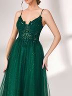 Bathed in soft light, a woman radiates elegance in a dark green evening gown. With sequin - dotted tulle, lace bodice, and spaghetti straps, it crafts a dreamy and refined look for formal events.6
