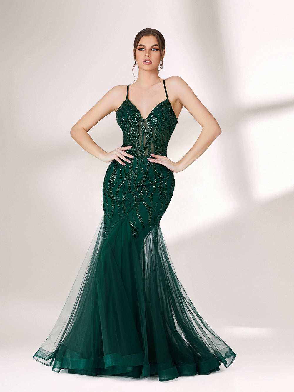 ：Illuminated softly, a woman captivates in a dark green evening gown. With sequin - tulle, mermaid silhouette, and sheer details, it creates a glamorous and sophisticated look for formal events.1