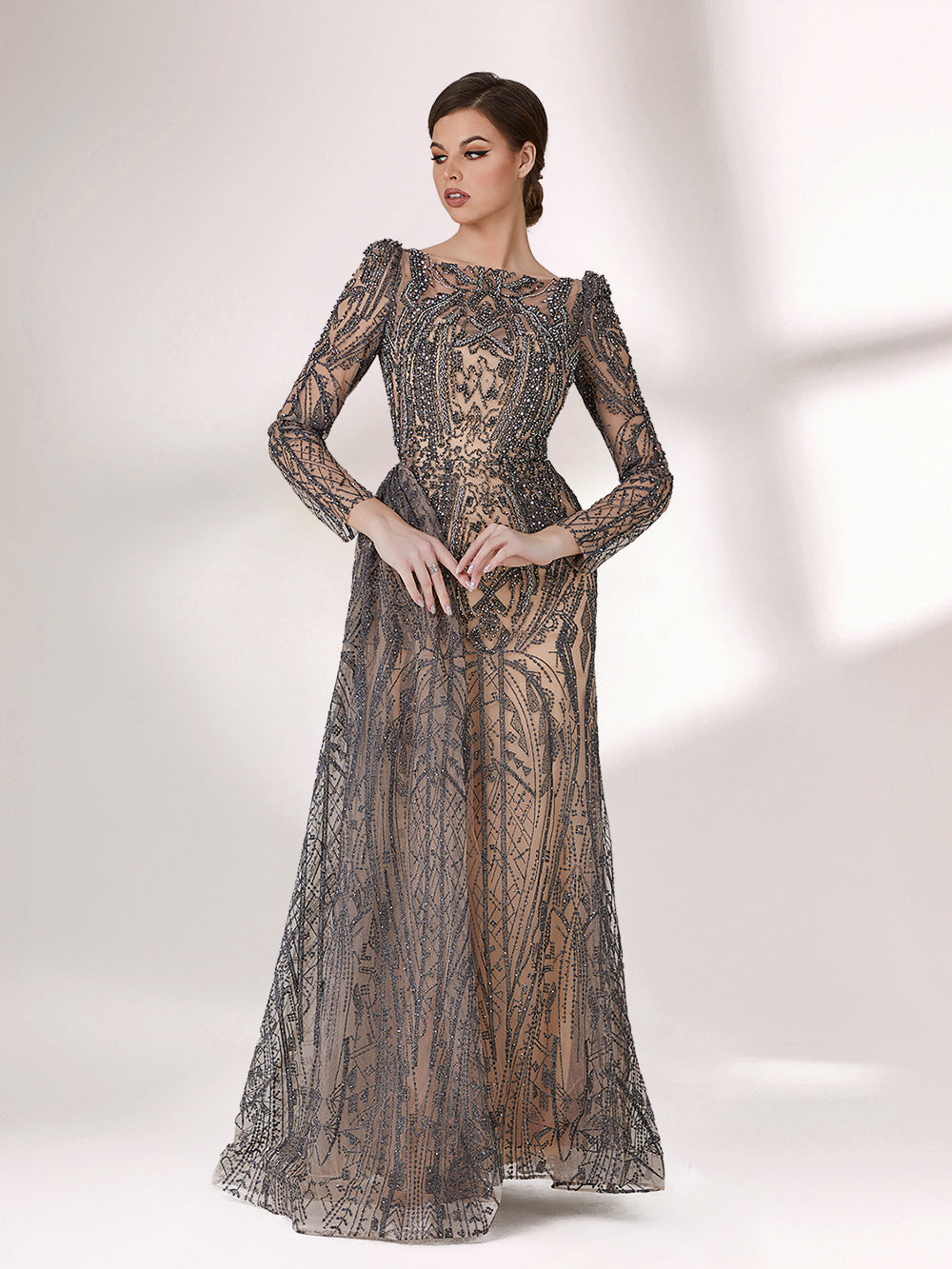 Under subtle lighting, a woman exudes elegance in a long - sleeved evening gown. The gown features a bateau neckline, intricate beadwork and lace patterns, creating a sheer - effect that's both sophisticated and alluring. Ideal for high - end formal occasions, it seamlessly combines luxury and grace.1