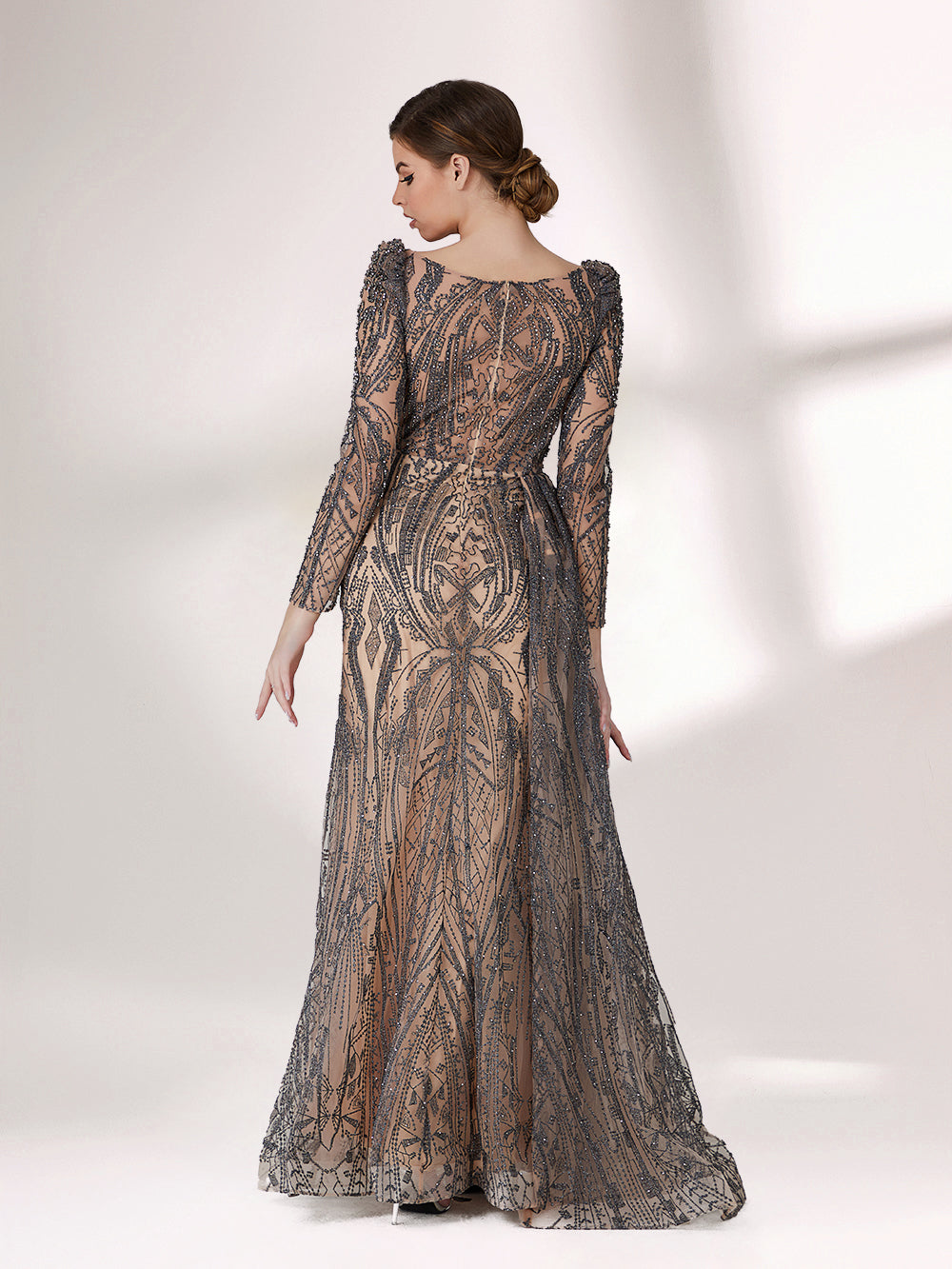 Under subtle lighting, a woman exudes elegance in a long - sleeved evening gown. The gown features a bateau neckline, intricate beadwork and lace patterns, creating a sheer - effect that's both sophisticated and alluring. Ideal for high - end formal occasions, it seamlessly combines luxury and grace.4