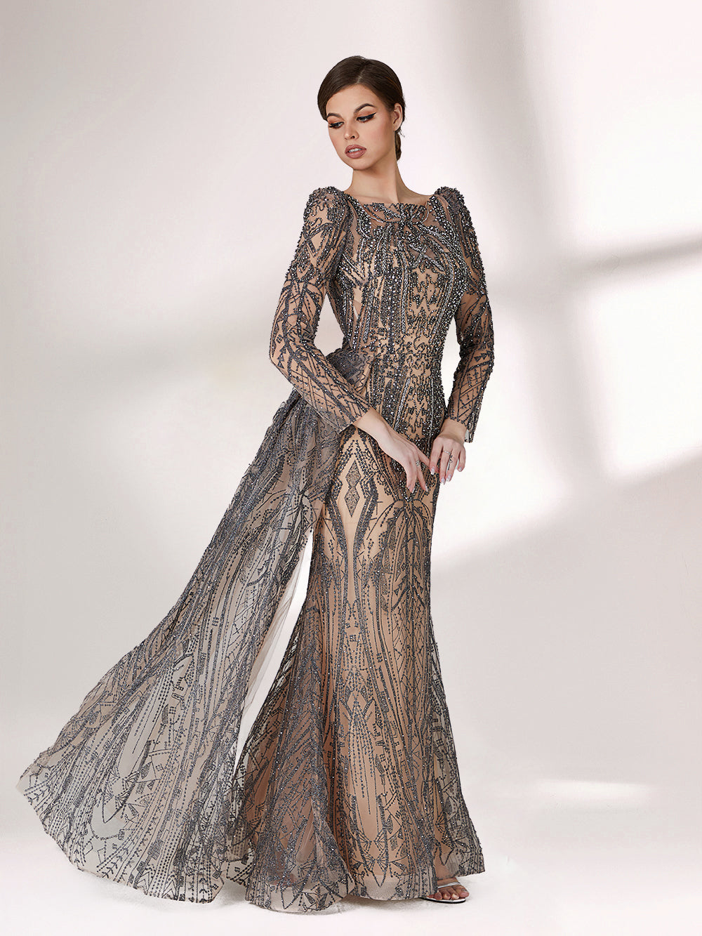 Under subtle lighting, a woman exudes elegance in a long - sleeved evening gown. The gown features a bateau neckline, intricate beadwork and lace patterns, creating a sheer - effect that's both sophisticated and alluring. Ideal for high - end formal occasions, it seamlessly combines luxury and grace.3