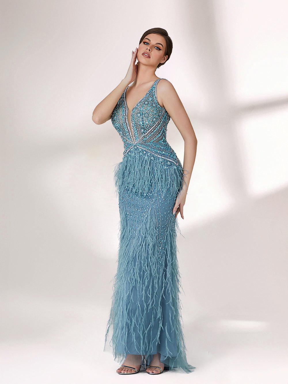 In soft lighting, a woman dazzles in a blue evening gown. With feather details, sequin embellishments, and a mermaid silhouette, it creates a luxurious and eye - catching look for formal events.1