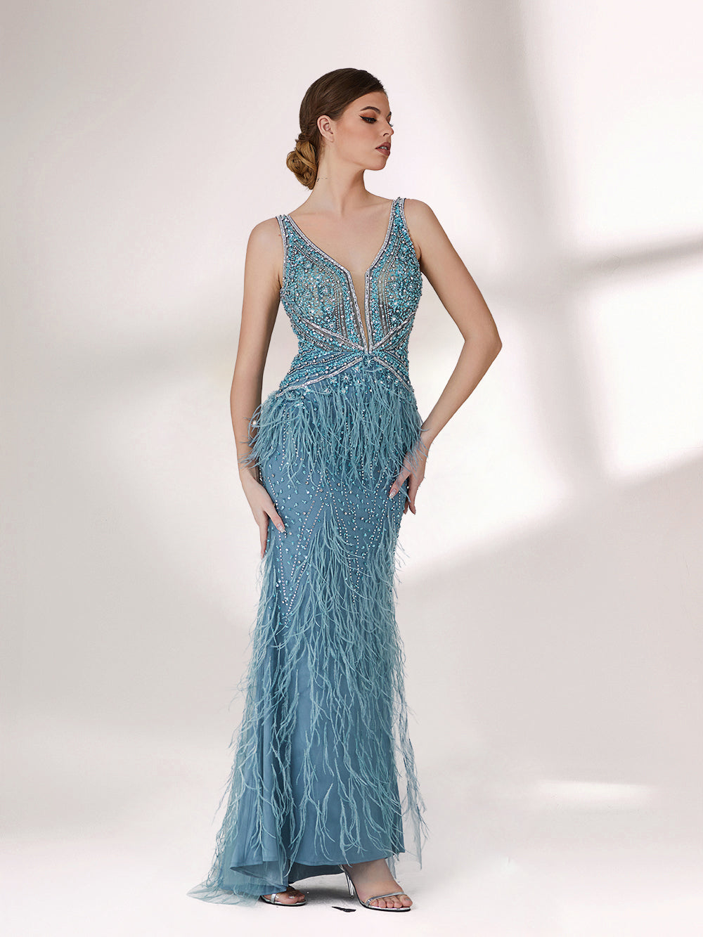 In soft lighting, a woman dazzles in a blue evening gown. With feather details, sequin embellishments, and a mermaid silhouette, it creates a luxurious and eye - catching look for formal events.3