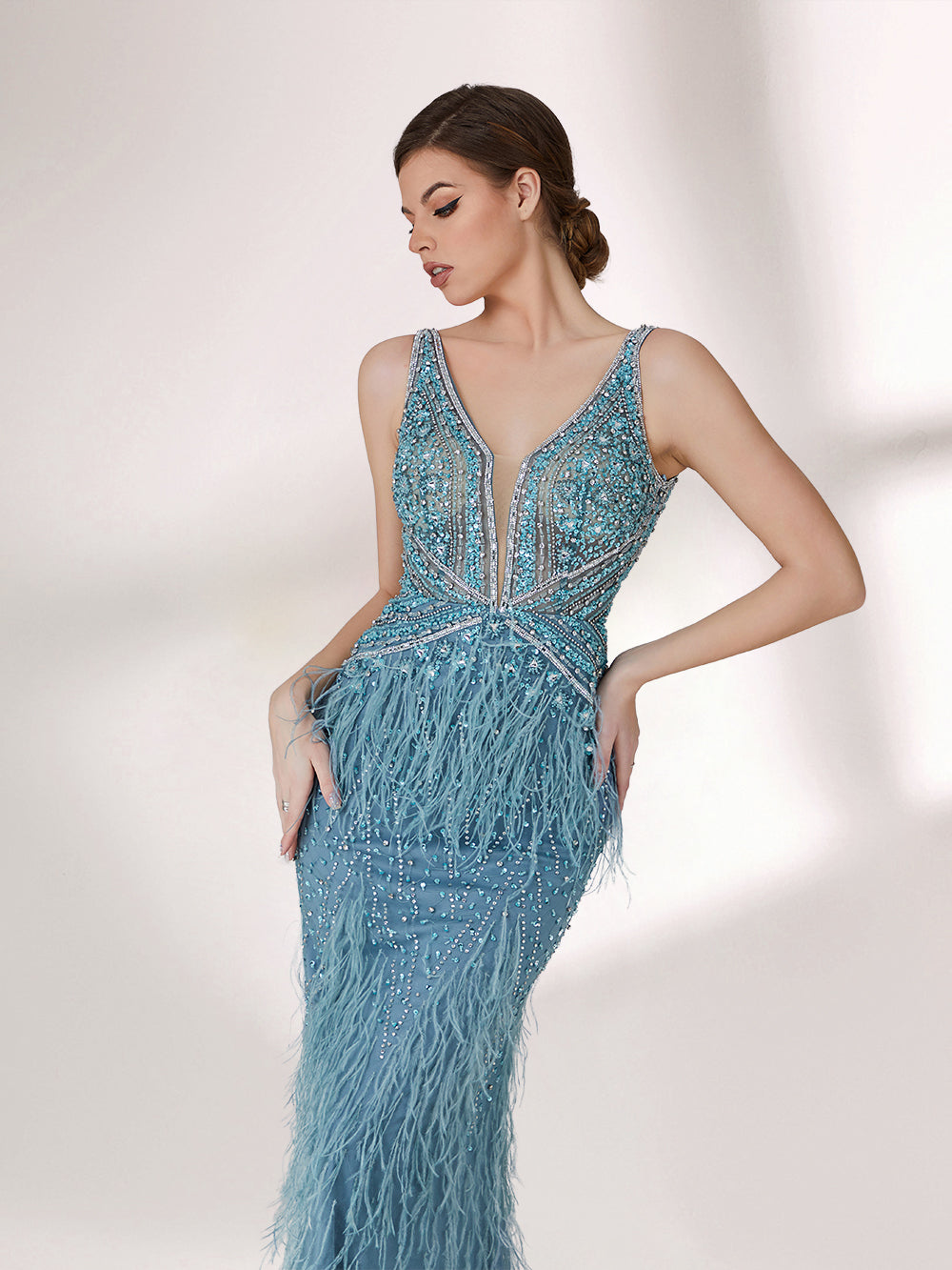 In soft lighting, a woman dazzles in a blue evening gown. With feather details, sequin embellishments, and a mermaid silhouette, it creates a luxurious and eye - catching look for formal events.4