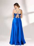 In soft lighting, a woman stuns in a royal blue evening gown. With spaghetti straps, lace detailing, and a high slit, it creates an elegant and bold look for formal events.2