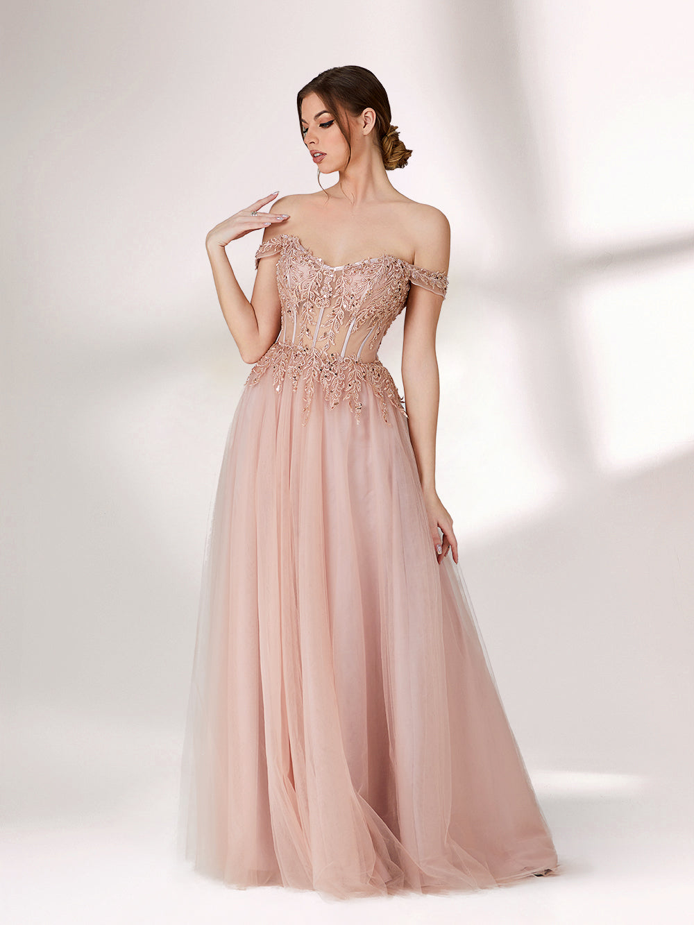 A woman stands against a light background, wearing a blush - pink evening gown. It has an off - the - shoulder design with a sweetheart neckline. The bodice is adorned with intricate lace and bead embroidery, and the skirt is made of flowing tulle, creating an elegant and romantic look, perfect for formal events.1
