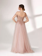 A woman stands against a light background, wearing a blush - pink evening gown. It has an off - the - shoulder design with a sweetheart neckline. The bodice is adorned with intricate lace and bead embroidery, and the skirt is made of flowing tulle, creating an elegant and romantic look, perfect for formal events.3